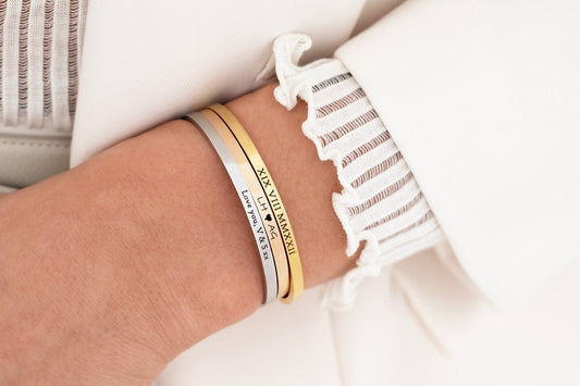Close-up of a wrist wearing multiple bracelets with visible text on a light background best gift